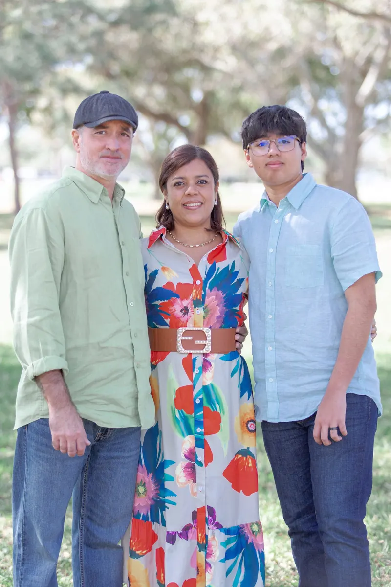 Mom, dad and their teenage son standing together outdoors